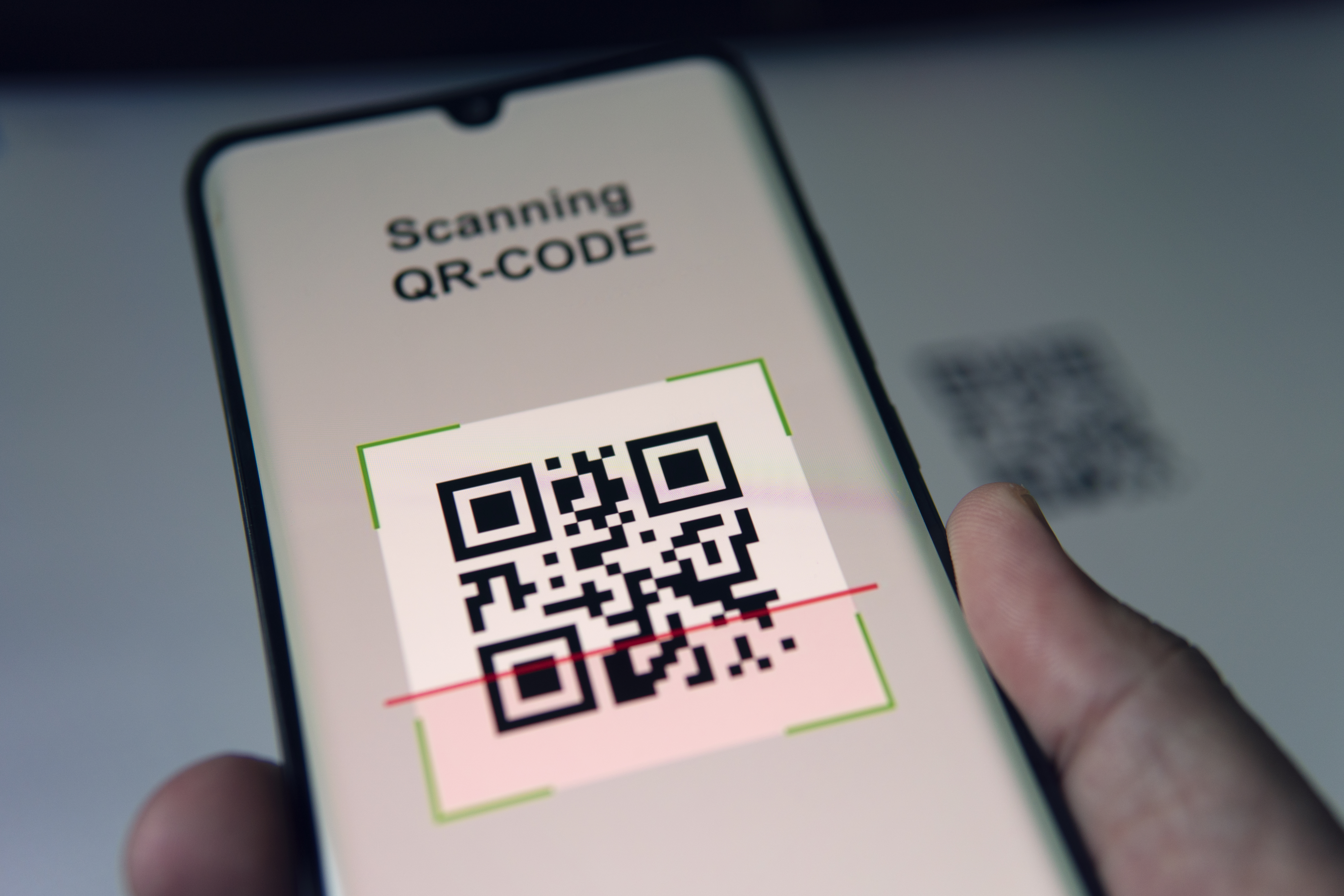 Une personne scanne avec son téléphone un QR code