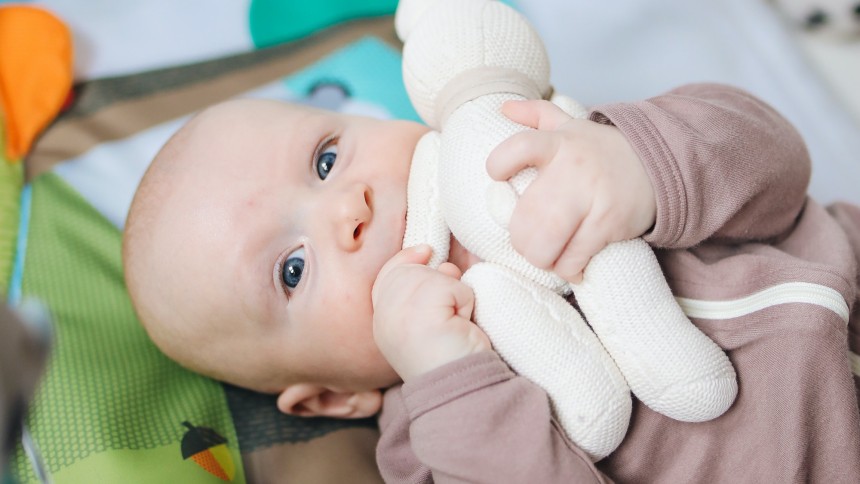 Bébé jouant avec une peluche dans sa chambre