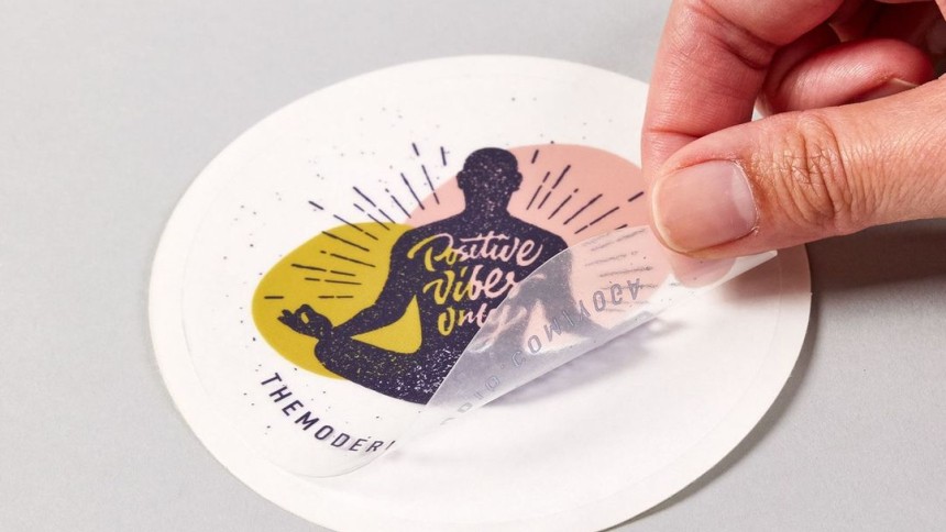 Main qui décolle un sticker transparent