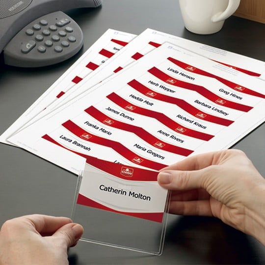 Mains en train de glisser un insert badge personnalisé dans une pochette porte-badge