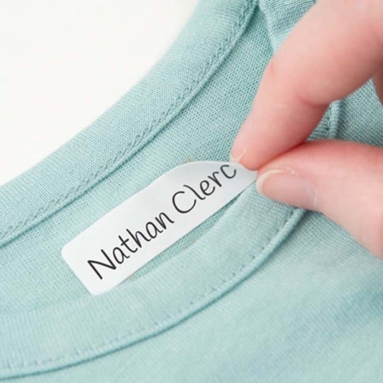main collant une etiquette vêtement autocollante sur un tshirt bleu