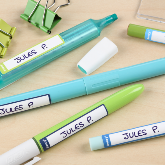 Etiquettes stylos bleues et vertes collées sur des stylos, crayons et feutres