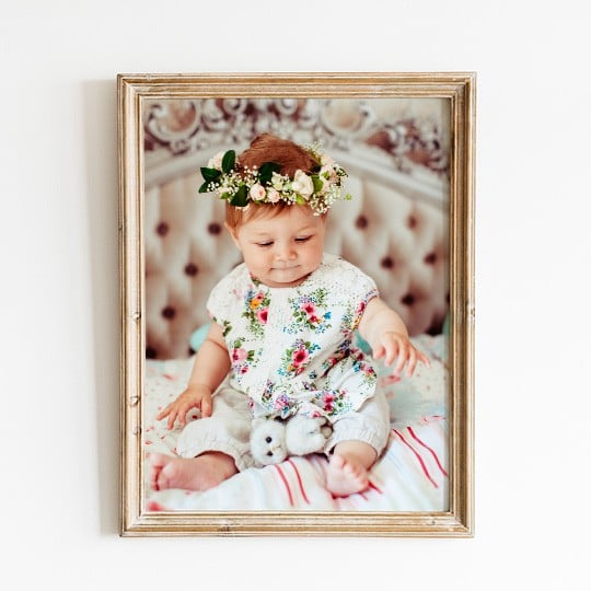 Photo d'un enfant imprimée sur du papier photo et encadrée dans un cadre doré