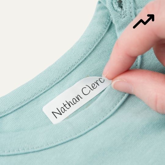 Main qui pose une étiquette autocollante pour vêtement