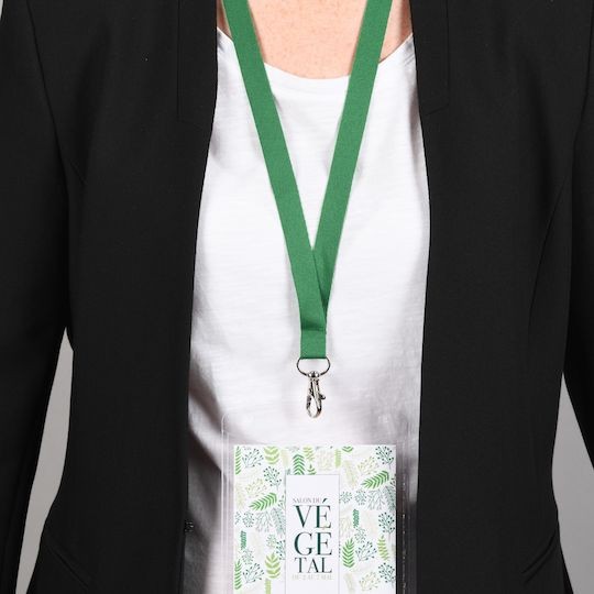 Personne portant un badge évènementiel avec tour de cou vert