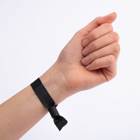 Bracelet noir en tissu porté au poignet