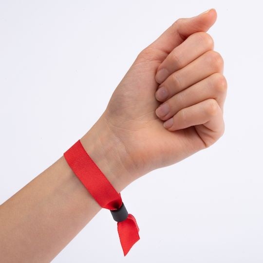 Bracelet rouge en tissu porté au poignet