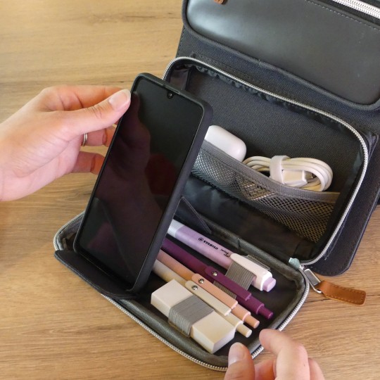 La pochette nomade contient plusieurs poches et un support de téléphone