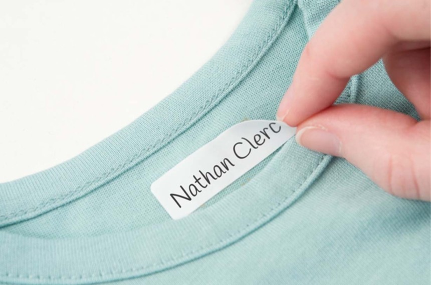 main collant une etiquette vêtement autocollante sur un tshirt bleu