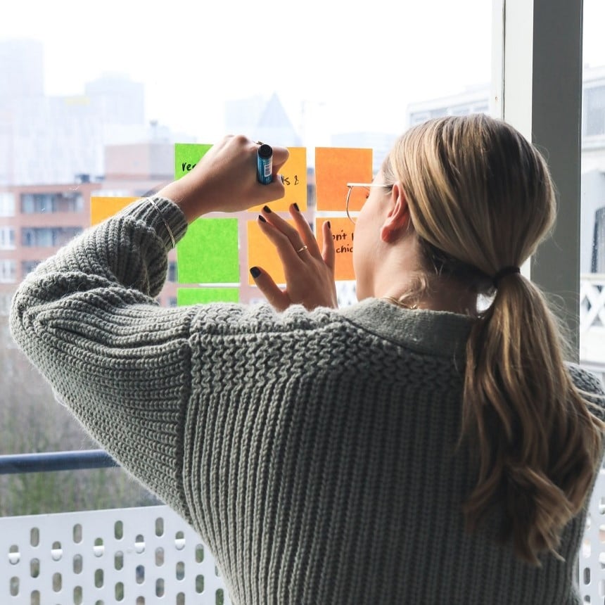 Une personne qui écrit les objectifs de l'entreprise sur des posts-it