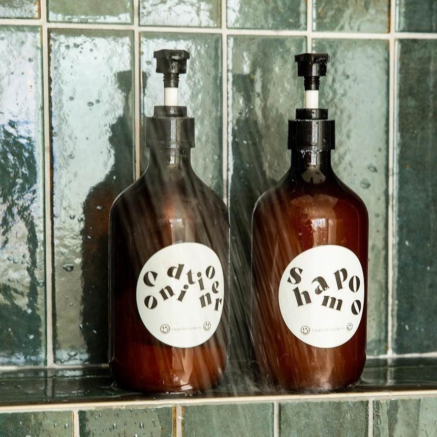 Etiquettes waterproof collées sur des flacons de shampoing et conditionner sous la douche