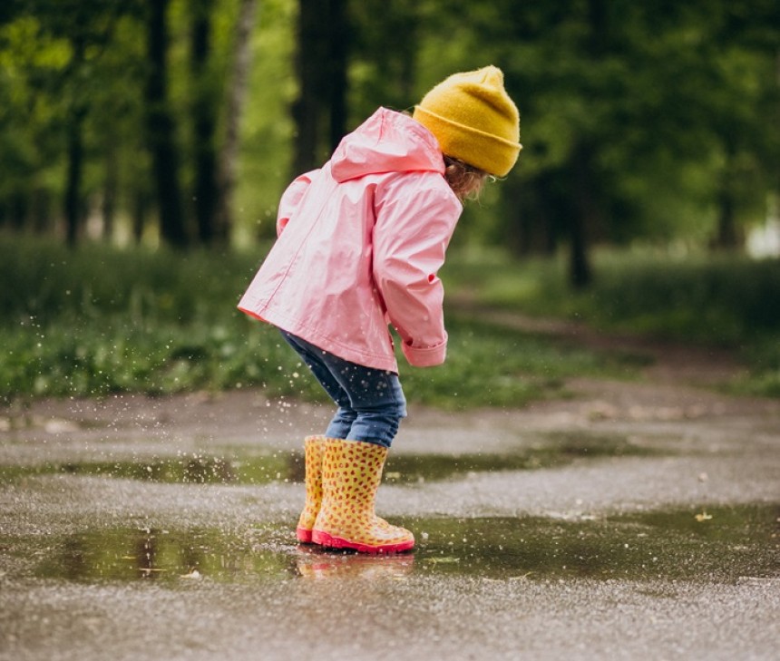 Photo d'une petite fille qui est en classe verte et qui saute dans une flaque d'eau