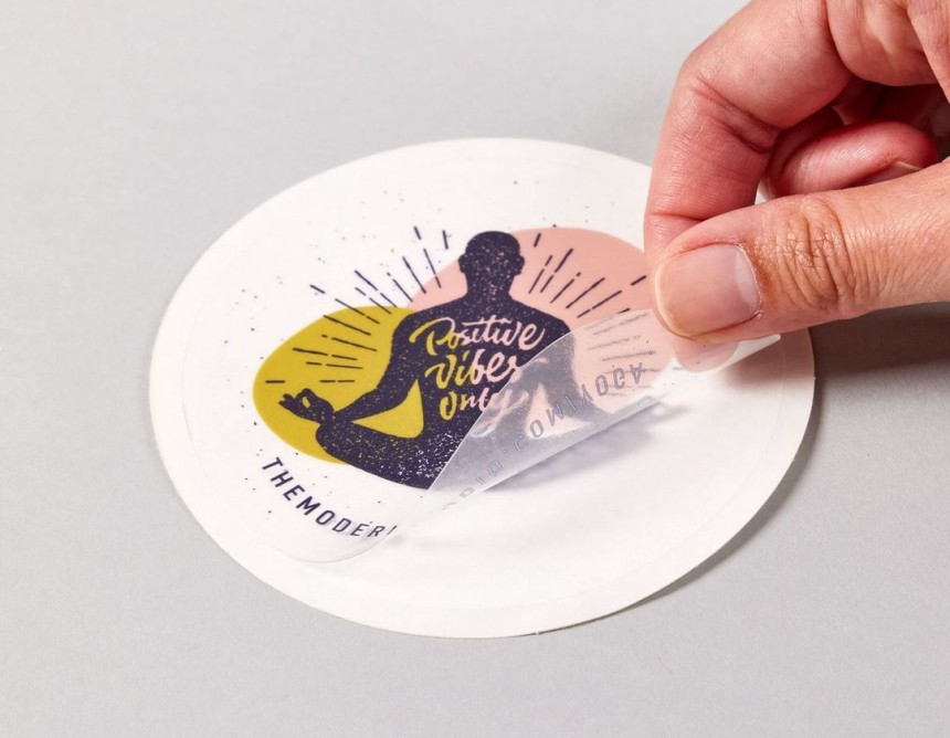 Main qui décolle un sticker transparent