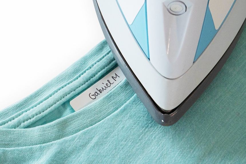 Application d'une étiquette thermocollante blanche avec un fer à repasser