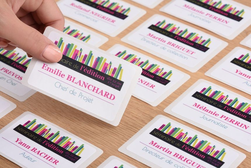 Badges autocollants présentés individuellement sur une table grâce à la prédécoupe
