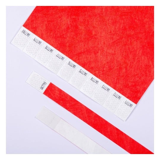 L'image montre du papier rouge avec plusieurs échantillons de matériau en bas. Les échantillons comportent des motifs zigzag et des annotations.