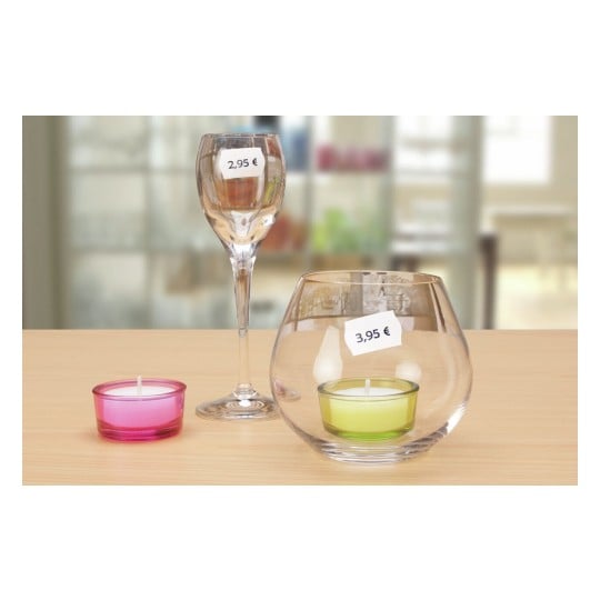 L'image montre des bougies dans des contenants en verre, avec des étiquettes de prix de 2,95 € et 3,95 €. Les bougies sont de différentes couleurs et sont disposées sur une table en bois.