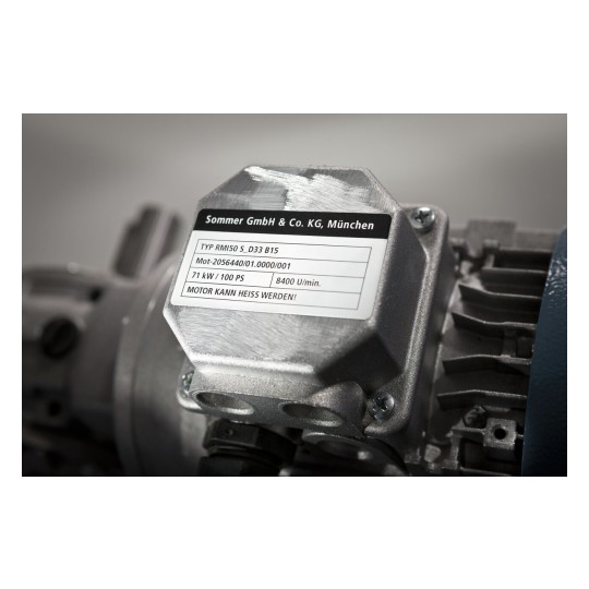 L'image montre un moteur avec une étiquette en métal indiquant les détails du moteur, y compris le type, le numéro de série et la puissance en kilowatts.