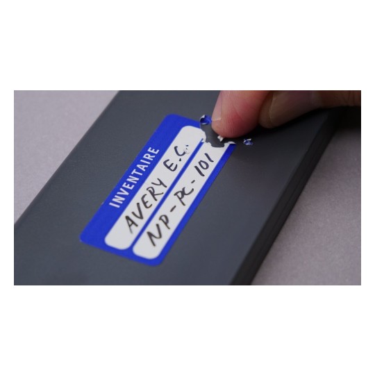 Il s'agit d'une étiquette bleue sur un objet, avec un texte manuscrit, indiquant 'INVENTAIRE', 'AVERY E.C.' et un numéro de code 'NP-PC-101'. Une main est en train de toucher l'étiquette.