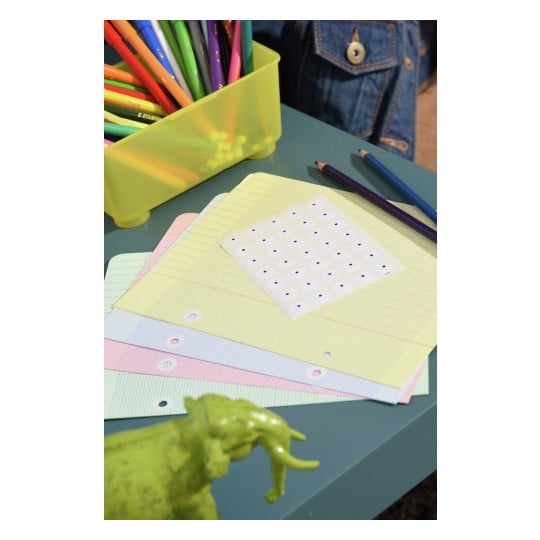 L'image montre un bureau avec des feuilles de papier colorées, des marqueurs dans un récipient jaune, et une petite figurine d'éléphant verte.