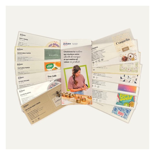Une image montrant un dépliant de produits Avery avec des exemples de papiers et d'étiquettes, accompagné d'une femme qui personnalise des bocaux.