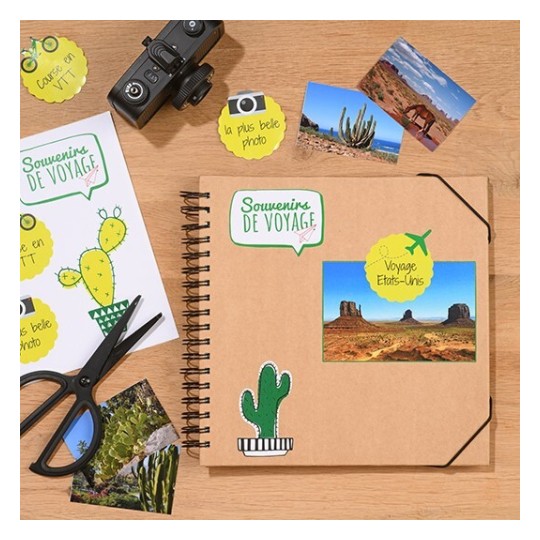 L'image montre un carnet de souvenirs de voyage avec des photos, un appareil photo, des ciseaux et des étiquettes. Le carnet est décoré de dessins de cactus et de mots en français.