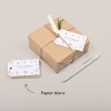 Etiquette américaine en papier blanc avec un design de Noël, attachées à un paquet cadaeau