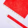 L'image montre du papier rouge avec plusieurs échantillons de matériau en bas. Les échantillons comportent des motifs zigzag et des annotations.