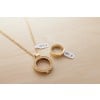 Une image montrant un collier doré avec un pendentif circulaire et une bague assortie. Les deux accessoires sont étiquetés avec des prix en euros.