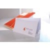 L'image montre une enveloppe blanche avec un logo et une adresse, placée à côté d'un dossier orange.