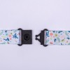 L'image montre une sangle colorée avec des motifs floraux tenue par des attaches noires.