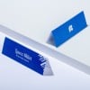 L'image montre deux cartes de visite en bleu. La première indique 'Laura Millot' avec le titre 'Responsable logiciel'. La seconde présente un logo ou un symbole simple.