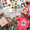 L'image montre des cadeaux de Noël joliment emballés avec des décorations, des étiquettes et des éléments festifs sur une table en bois.